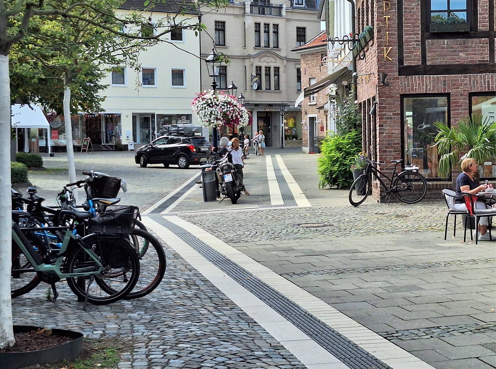 Blick über den fast fertigen Lindenplatz mit Kopfsteinpflaster, Geschäften und Passanten